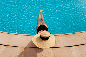 Fototapeta na wymiar Beautiful woman sunbathing by the pool top view horizontal. Summer background. Poster, mock up for design