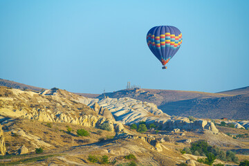 Colorful balloon flying over a clear blue sky during a sunset on a sunny day in Cappadocia, Turkey, copy space