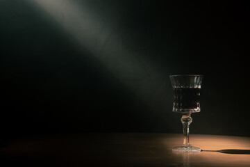 a glass of wine with a narrow beam of light