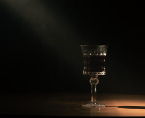 a small beam of light falls on a crystal glass of wine