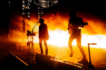 Silhouette of rock band. Bright stage lights.