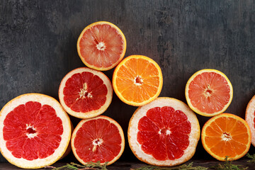 Grapefruit and oranges against a gray wall. Juicy fruits with vitamins