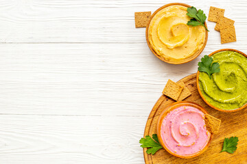 Green and purple hummus with spinach and beets in bowls, top view