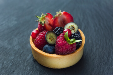 Sweet dessert with fruits, cake. Photo of food on a dark background