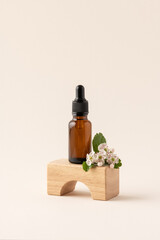Mock up amber glass bottle on wooden podium on trendy beige background with flowers. Dropper glass,  concept of beauty spa salon, body care, natural skincare cosmetics, product display presentation