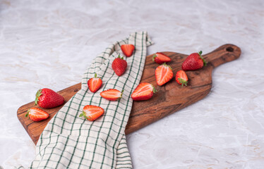 Geschnittene, halbierte Erdbeeren auf Holzbrett, frische Früchte