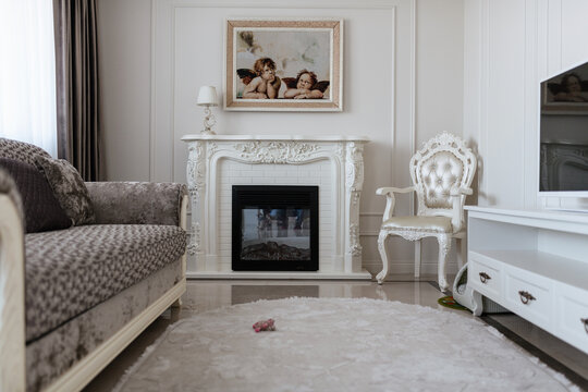 Modern interior design of the room with fireplace and sofa in white tones