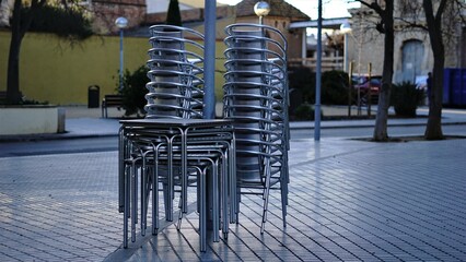 tables and chairs stacked on the sidewalk