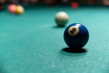 Colorful isolated balls on the pool table. Balls on a blurry green background.
