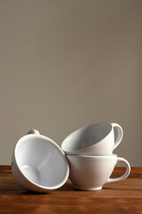 Artisan style cups and plates on wooden table and window light still life with homemade bread on the plates.