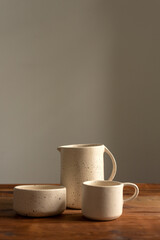 Artisan style cups and plates on wooden table and window light still life with homemade bread on the plates.