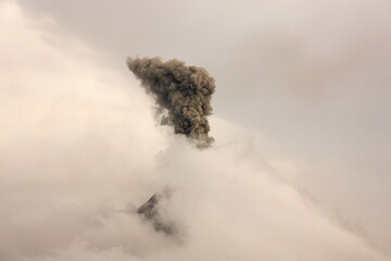 Volcano Errupting Through Clouds