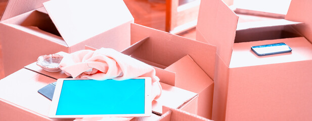 Empty cardboard boxes ready to be open along with a tablet with green screen, moving to a new home concept.