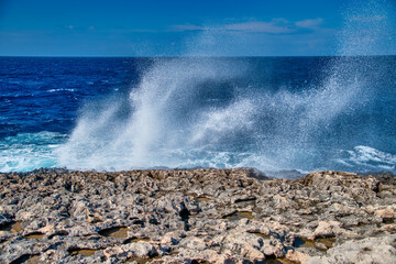 Sea water spray of crushing waves against rocks