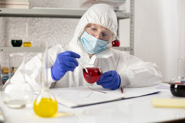 Scientist writing test result and tube liquid reagent. Lab scientist in chemical laboratory