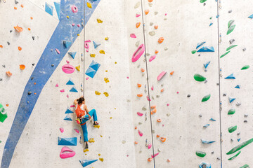 Young Woman rock climbing indoors. - 501204050