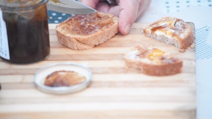 Man preparing a deliciuos fig jelly with bread outdoor
