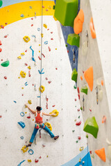 Obraz premium Young Woman rock climbing indoors.