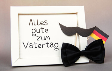 happy father day in german note board with bow tie, a mustache and flag of Germany
