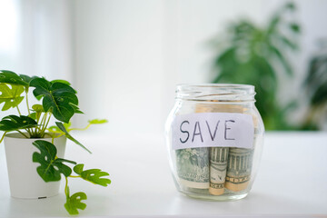 Glass jar with dollars and text: save. Money saving concept. Credit. Copy space.
