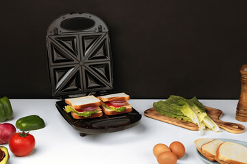 Electric kitchen sandwich maker on non isolated background - obrazy, fototapety, plakaty