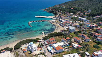 Aerial drone photo of iconic picturesque village, main port and beautiful turquoise beaches of Skala featuring landmark church of Agioi Anargiroi, Agistri island, Saronic gulf, Greece