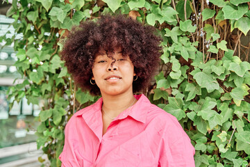 Naklejka premium portrait of an African-American woman looking into the camera with curly hair and a curvy body.