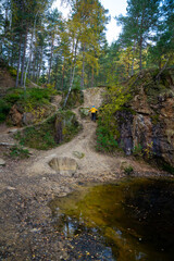 The little boy climbs the steep trail to the top. There is a small lake below