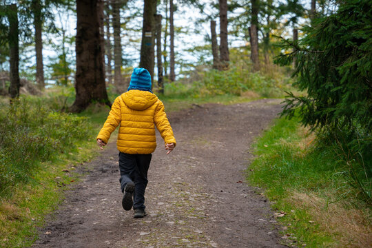 A happy child is running on a mountain trail