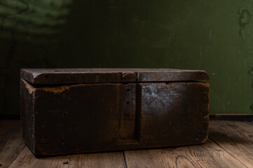 An old box in a dark room. Old closed wooden box. Cache in a wooden box.