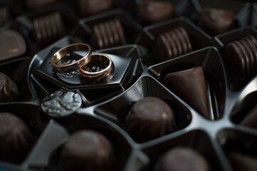Wedding rings lie on the chocolate box