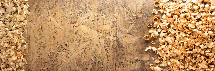 Wood shavings at table background. Wooden shaving on old plank board