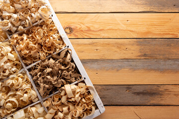 Wood shavings at table background. Wooden shaving on old plank board