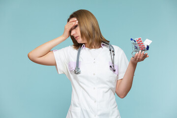 high price of drugs and medicine. Inflation, imitation. A woman doctor shows a miniature basket of medicines, on a blue background. Copy paste. healthcare concept.