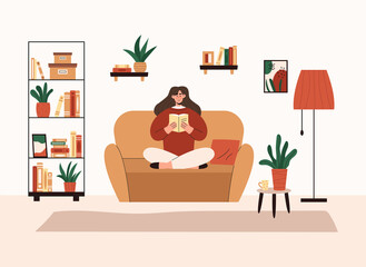 Woman sitting on sofa and reading book