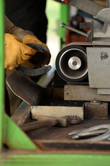 Hufschmiedin bei der Arbeit im Pferdestall