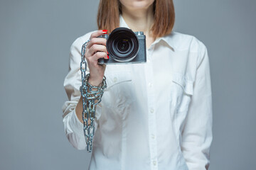 Copyright. The camera is chained to the photographer's hand. The concept of protecting the photographer from theft of his photos. Isolated on a gray background.