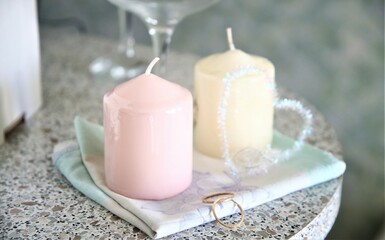 Fototapeta na wymiar Closeup candles and wedding rings on the table flame light decorate marry heart love