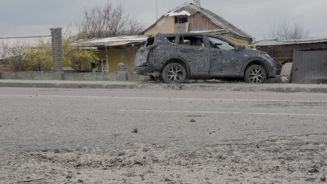 Aftermath shell of civilian bombed city damage car shooting bullet holes shot. Bomb attack Russia war damage Ukraine 2022 Russian invasion of Ukraine war torn city destroyed car shrapnel holes traces