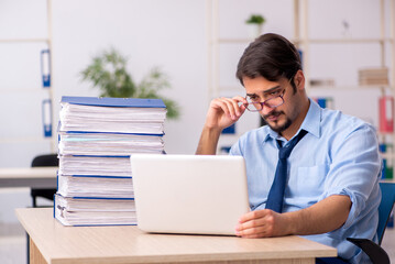 Young male employee and too much work in the office