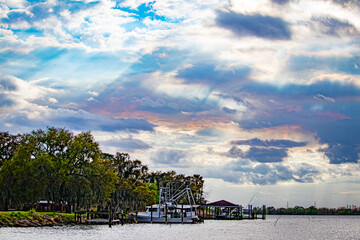 Sunlight Breaks through the Clouds and Turns Them Pink as It Shines Down on the Boats and Bayou Waters in Lafitte, Louisiana, USA
