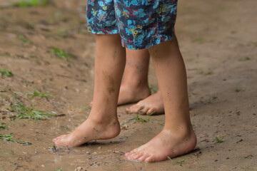 Fototapeta na wymiar children's feet treading on the mud