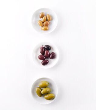 Three Types of Olives in Small White Dishes.