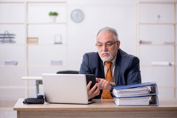 Fototapeta premium Aged male employee working in the office