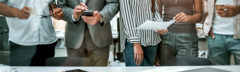 Office life. Cropped photo of business people standing together in the modern office