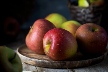 
Apples with large drops of water lying in a wooden plate