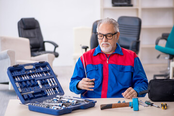 Old male repairman working at workshop
