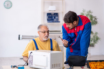 Two male repairmen working at workshop