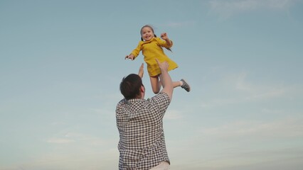 happy family park. little child girl flies against sky. father plays kid daughter baby superhero...