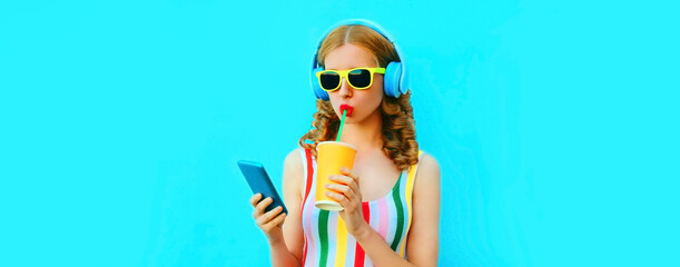 Summer colorful portrait of stylish happy young woman listening to music in headphones looking at...